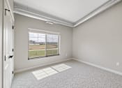 Thumbnail 25 of 76 - A room with a large window and a carpeted floor.