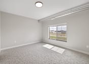 Thumbnail 27 of 76 - A room with a window and a carpeted floor.