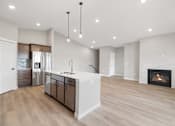 Thumbnail 41 of 76 - A modern kitchen with a fireplace and wooden floors.