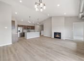 Thumbnail 57 of 76 - A spacious living room with a fireplace and a kitchen in the background.