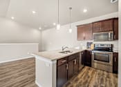 Thumbnail 36 of 39 - A kitchen with wooden floors and a white counter top.