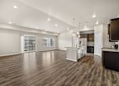 Thumbnail 29 of 39 - A spacious kitchen with a wooden floor and white walls.