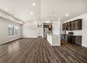 Thumbnail 28 of 39 - A spacious kitchen and living room with wood flooring and modern appliances.