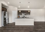 Thumbnail 26 of 39 - A modern kitchen with a white island and stainless steel appliances.