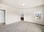 Thumbnail 30 of 39 - A spacious room with a door, a window, and a carpeted floor.