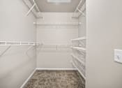 Thumbnail 33 of 39 - Empty walk-in closet with shelves and carpeted floor.