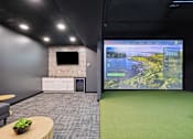 Thumbnail 40 of 88 - A golf simulator room with a large screen and tv.