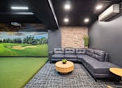 Thumbnail 42 of 88 - A golf simulator room with a large lounge couch.