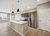 Thumbnail 60 of 88 - A kitchen with island and brown cabinets.