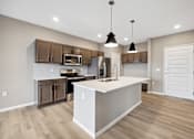 Thumbnail 58 of 88 - A kitchen with island and brown cabinets.