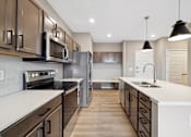 Thumbnail 53 of 88 - A kitchen with island and brown cabinets.