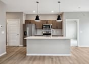 Thumbnail 54 of 88 - A kitchen with island and brown cabinets.