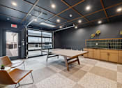 Thumbnail 11 of 88 - A room with a ping pong table and garage door.