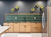 Thumbnail 48 of 88 - Kitchenette with green backsplash and light colored wood cabinets.