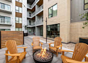 Thumbnail 78 of 88 - A fire pit sits in the middle of a patio surrounded by chairs.