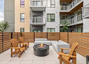 Thumbnail 3 of 88 - A patio with a fire pit, chairs and a couch.