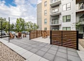 Thumbnail 74 of 88 - A modern outdoor patio area with a wooden fence and chairs.