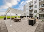 Thumbnail 82 of 88 - A patio with a table and chairs under a white pergola.