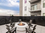 Thumbnail 84 of 88 - A fire pit on a patio surrounded by chairs.