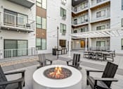 Thumbnail 87 of 88 - A fire pit sits in the middle of a patio surrounded by chairs.