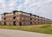 Thumbnail 1 of 37 - Apartment building with a green lawn in front.