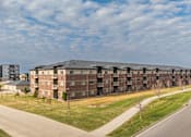 Thumbnail 36 of 37 - A large apartment complex with a road in front of it.