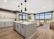 Thumbnail 11 of 61 - A modern kitchen with a large island and pendant lights.