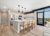 Thumbnail 1 of 61 - A modern kitchen with wooden floors and furniture.