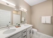 Thumbnail 14 of 61 - A bathroom with a white sink and a white toilet.