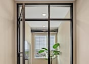 Thumbnail 17 of 61 - A modern hallway with a glass door leading to a balcony.