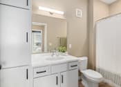 Thumbnail 19 of 61 - A white bathroom with a toilet, sink, and shower.