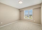 Thumbnail 24 of 61 - A room with a window and a carpeted floor.