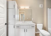 Thumbnail 31 of 61 - A white bathroom with a sink, toilet, and medicine cabinet.