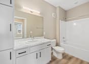 Thumbnail 27 of 61 - A white bathroom with a sink, toilet, and bathtub.