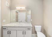 Thumbnail 21 of 61 - A bathroom with a marble countertop and white fixtures.