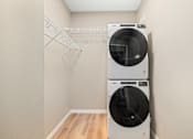 Thumbnail 20 of 61 - Two white front loading washing machines in a laundry room.