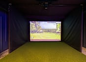 Thumbnail 5 of 88 - A screen in a dark room shows a golf course.