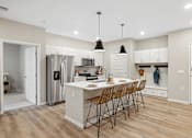 Thumbnail 12 of 88 - an open kitchen with a large island with bar stools