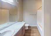 Thumbnail 17 of 19 - A bathroom with a toilet, sink, and mirror.