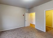 Thumbnail 14 of 19 - A room with a carpeted floor and two doors, one of which is open.