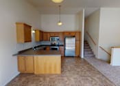 Thumbnail 2 of 17 - A kitchen with wooden cabinets and a tiled floor.