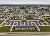 Thumbnail 7 of 36 - A large building complex with a parking lot in front.