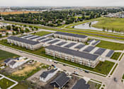 Thumbnail 36 of 36 - A large apartment complex with multiple buildings and a parking lot in front.