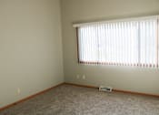 Thumbnail 7 of 18 - A room with a window covered by blinds and a carpet on the floor.
