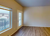 Thumbnail 13 of 19 - A room with wooden floors and a large window.