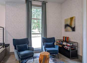 Thumbnail 11 of 58 - Two blue chairs are in front of a window with a grey curtain.