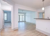 Thumbnail 18 of 58 - A large, empty room with wooden floors and white walls.
