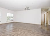 Thumbnail 21 of 30 - A room with a ceiling fan and wooden flooring.