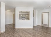 Thumbnail 28 of 30 - A spacious room with a large window and wooden flooring.