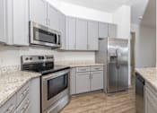 Thumbnail 10 of 30 - A kitchen with stainless steel appliances and white cabinets.